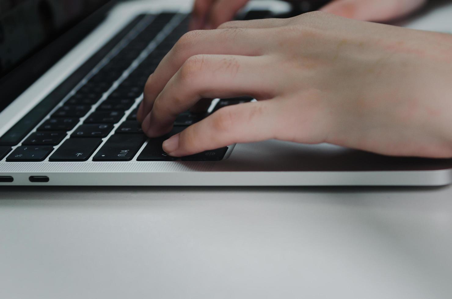 cerrar mano mujer escribiendo teclado computadora portátil en el escritorio.tecnología empresarial en línea y comunicación en el escritorio. foto