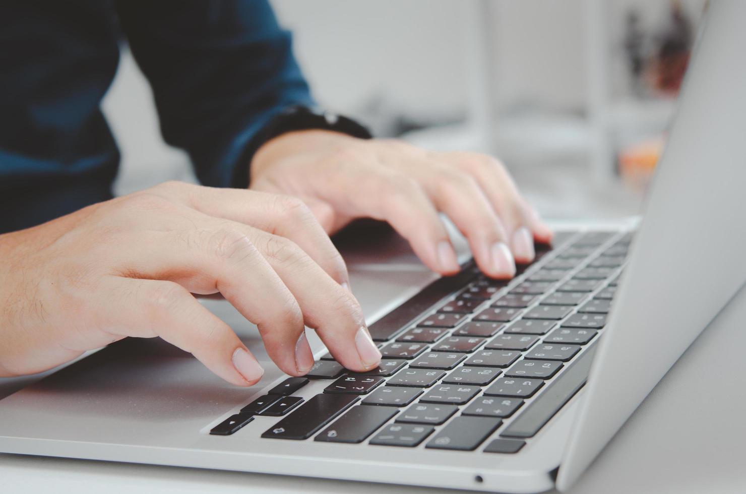 primer plano mano hombre escribiendo teclado computadora portátil en el escritorio.tecnología empresarial en línea y comunicación en el escritorio. foto