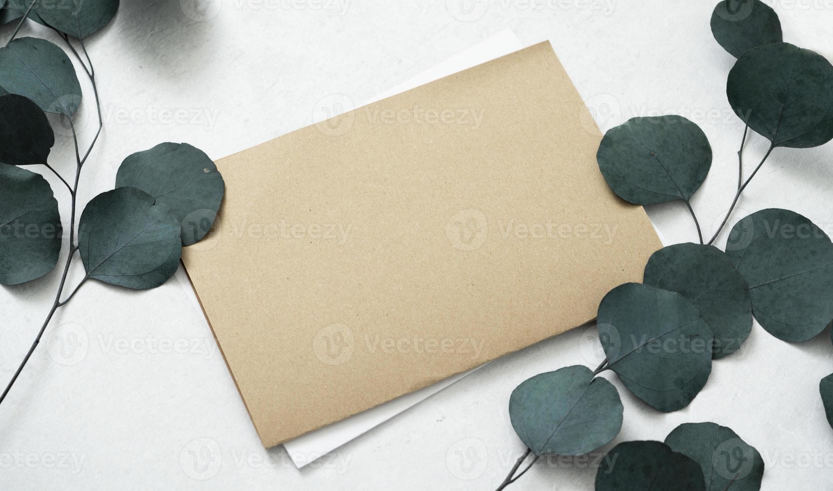 Mockup for a letter or a wedding invitation with leaves eucalyptus branches. photo