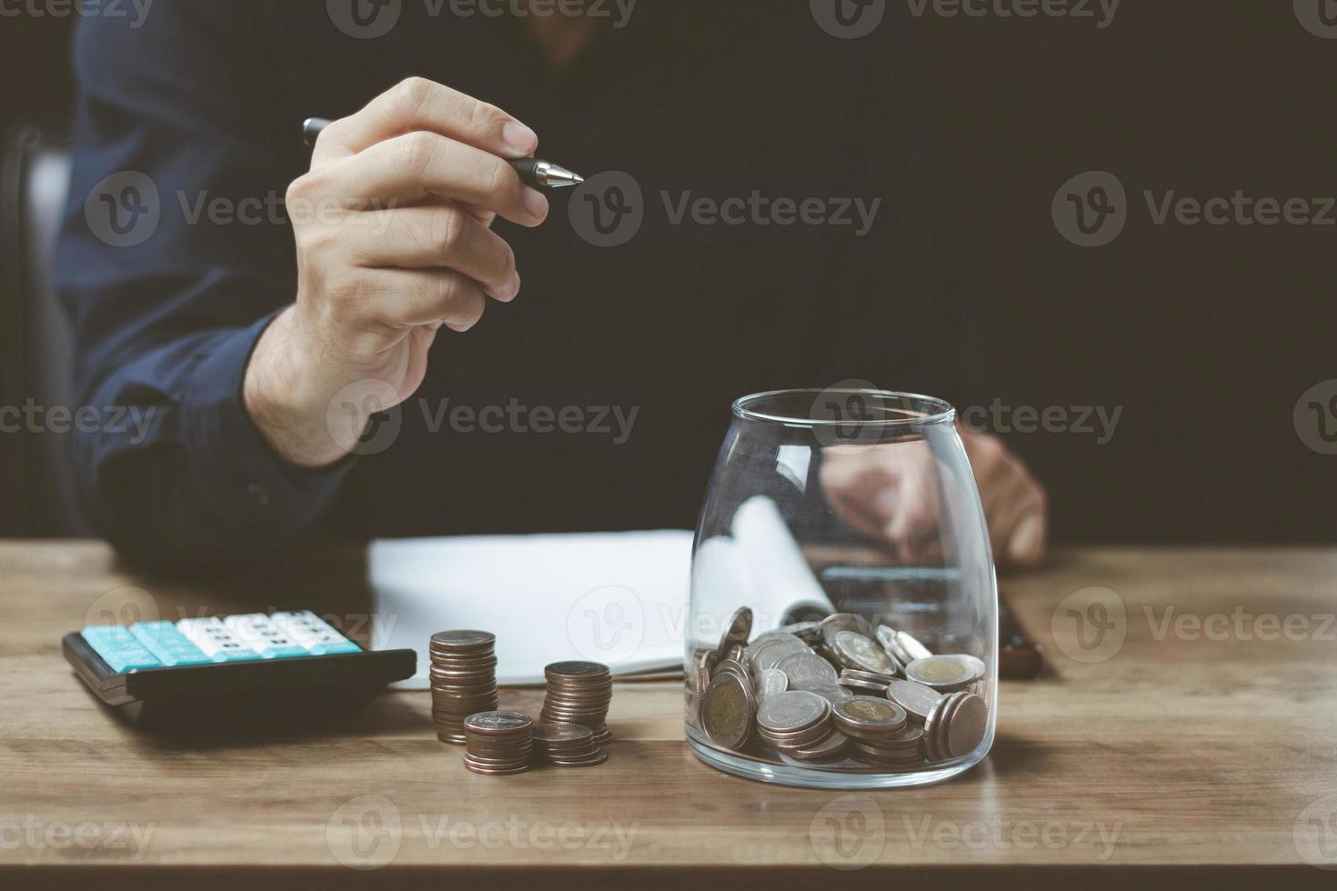 financial and investment technology concept ,man's hand using pen and a calculator to calculate financial and account numbers to invest money, make a marketing plan income and expenses photo