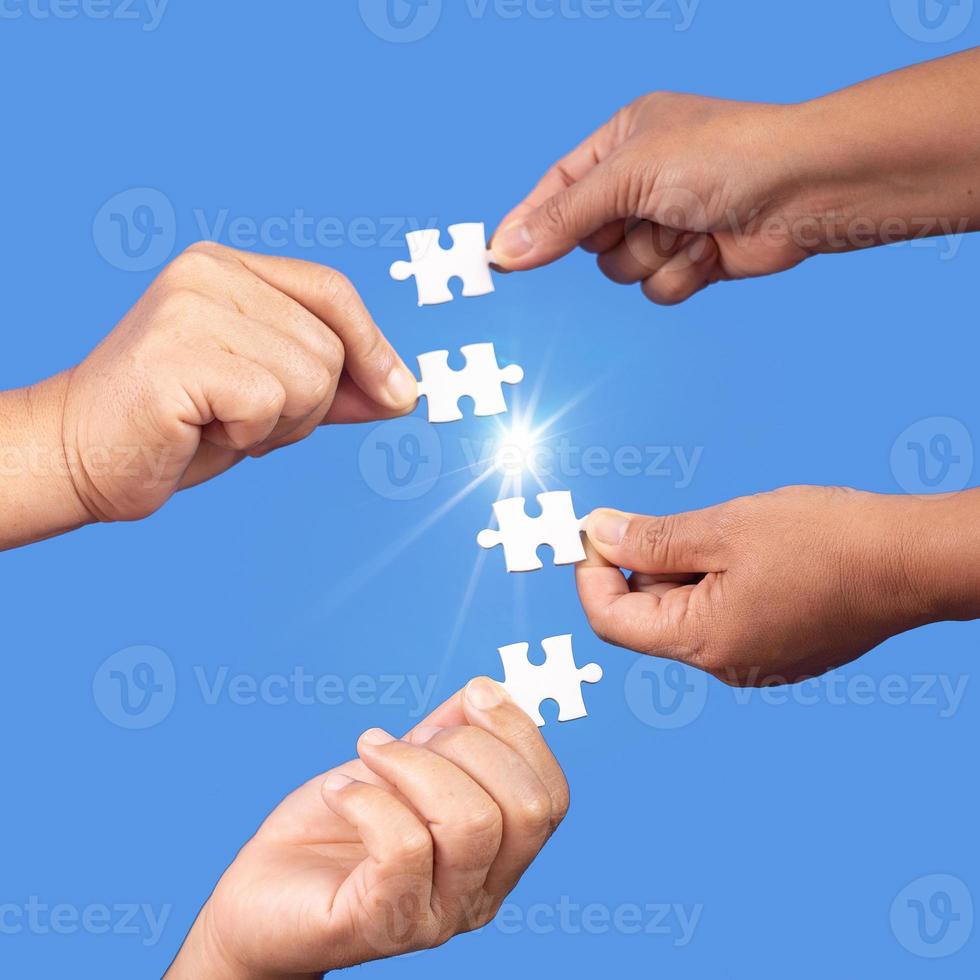 Hands holding jigsaw puzzles piece with clear blue background, success business, solution strategy, teamwork partnership concept photo
