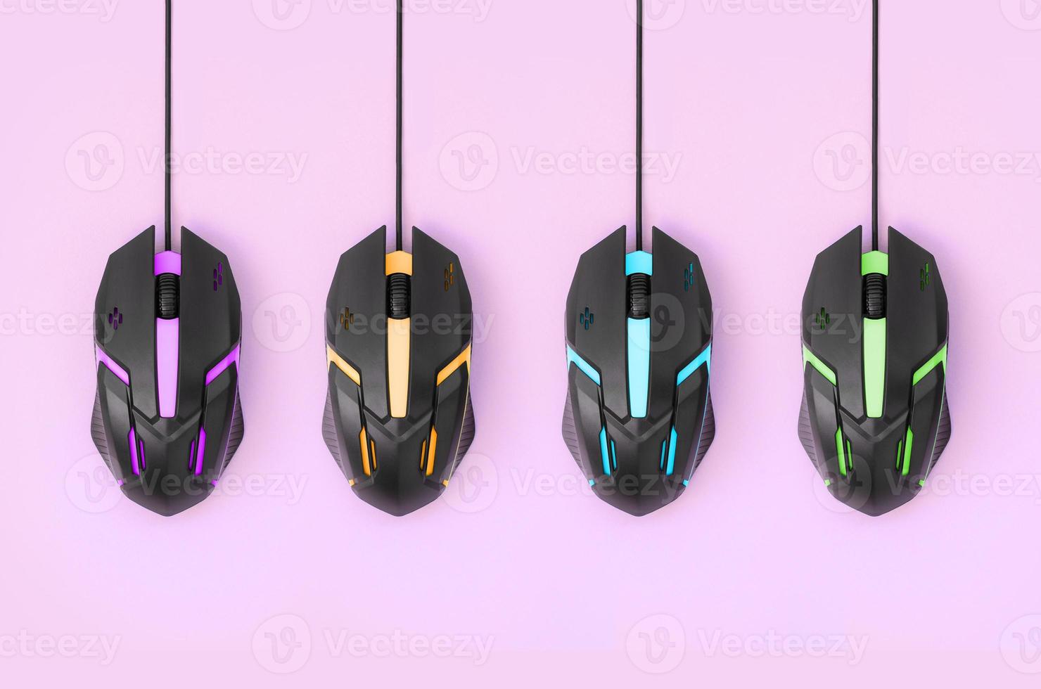 Black computer mouses hang on pastel pink background photo