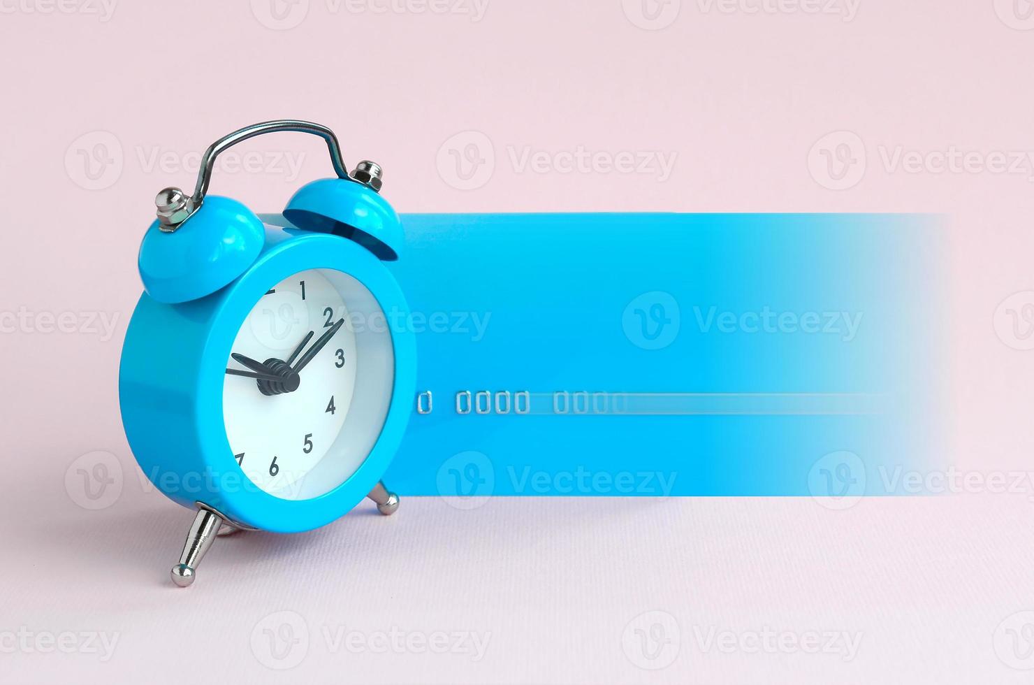 Small blue alarm clock and blue credit card photo