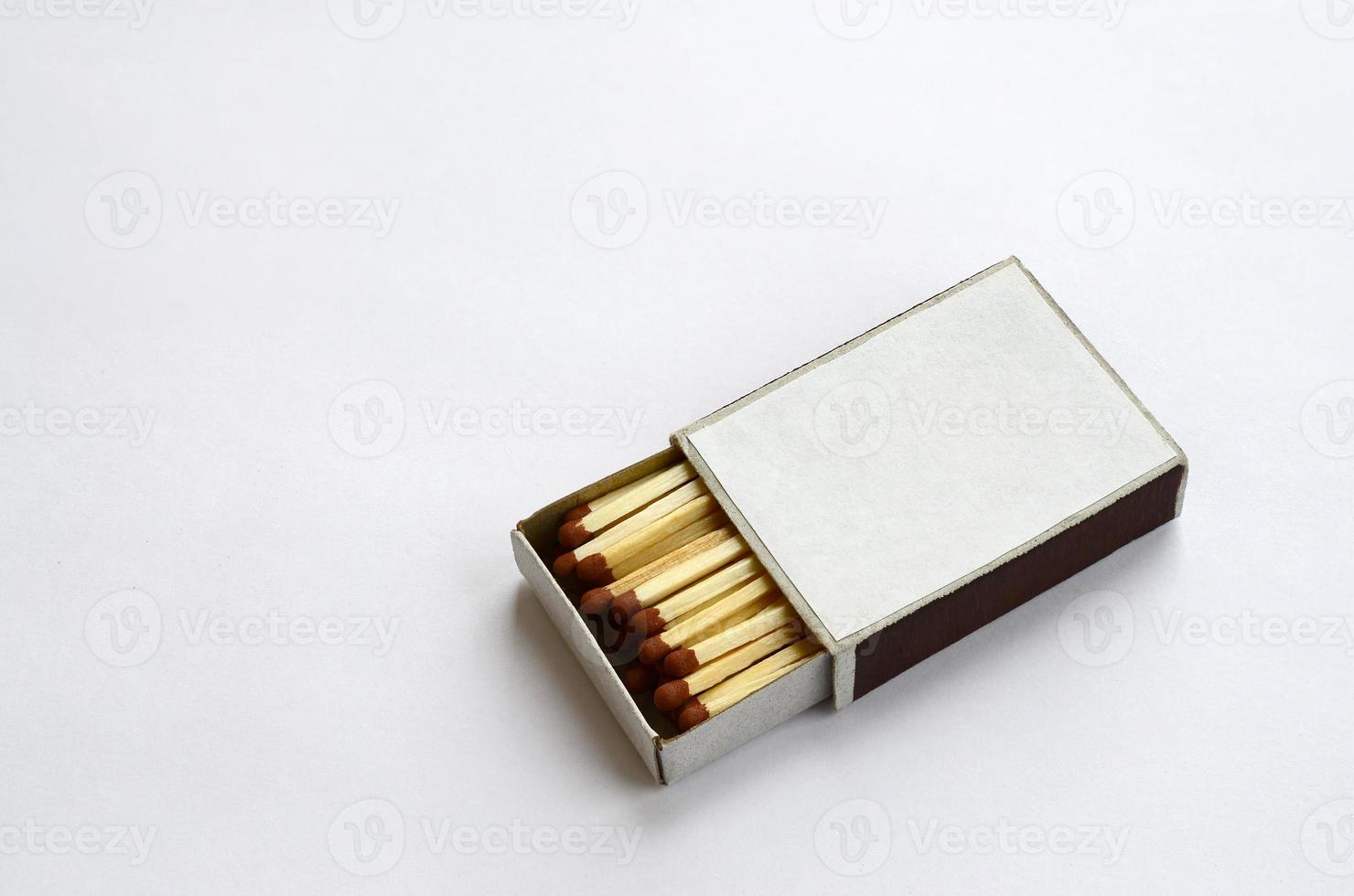 Open cardboard matchbox filled with matches on a white background photo