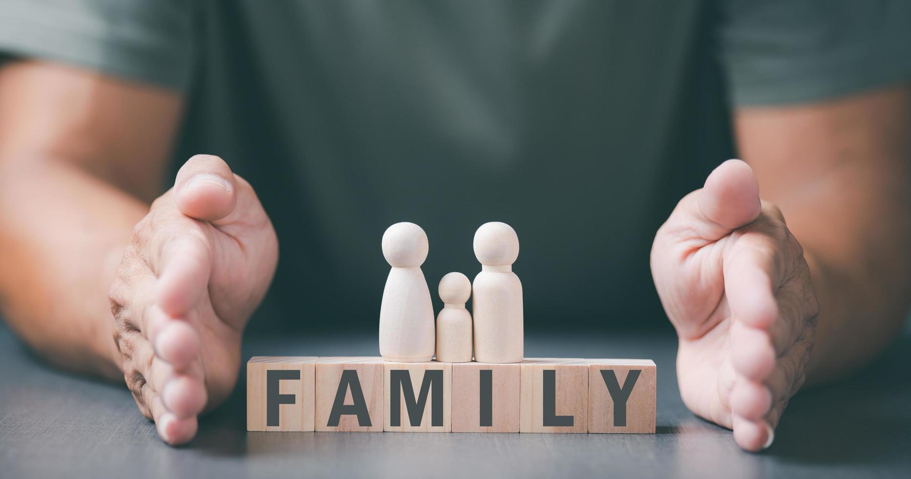 Father put his hand next to a wooden block to show protection for the family. and support and help advice The concept of family relationships to be connected to safety loving kindness photo