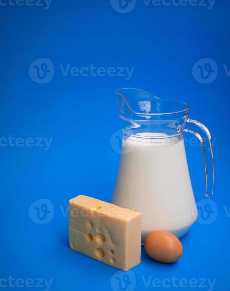 Dairy products. Milk, egg and cheese on a blue background photo