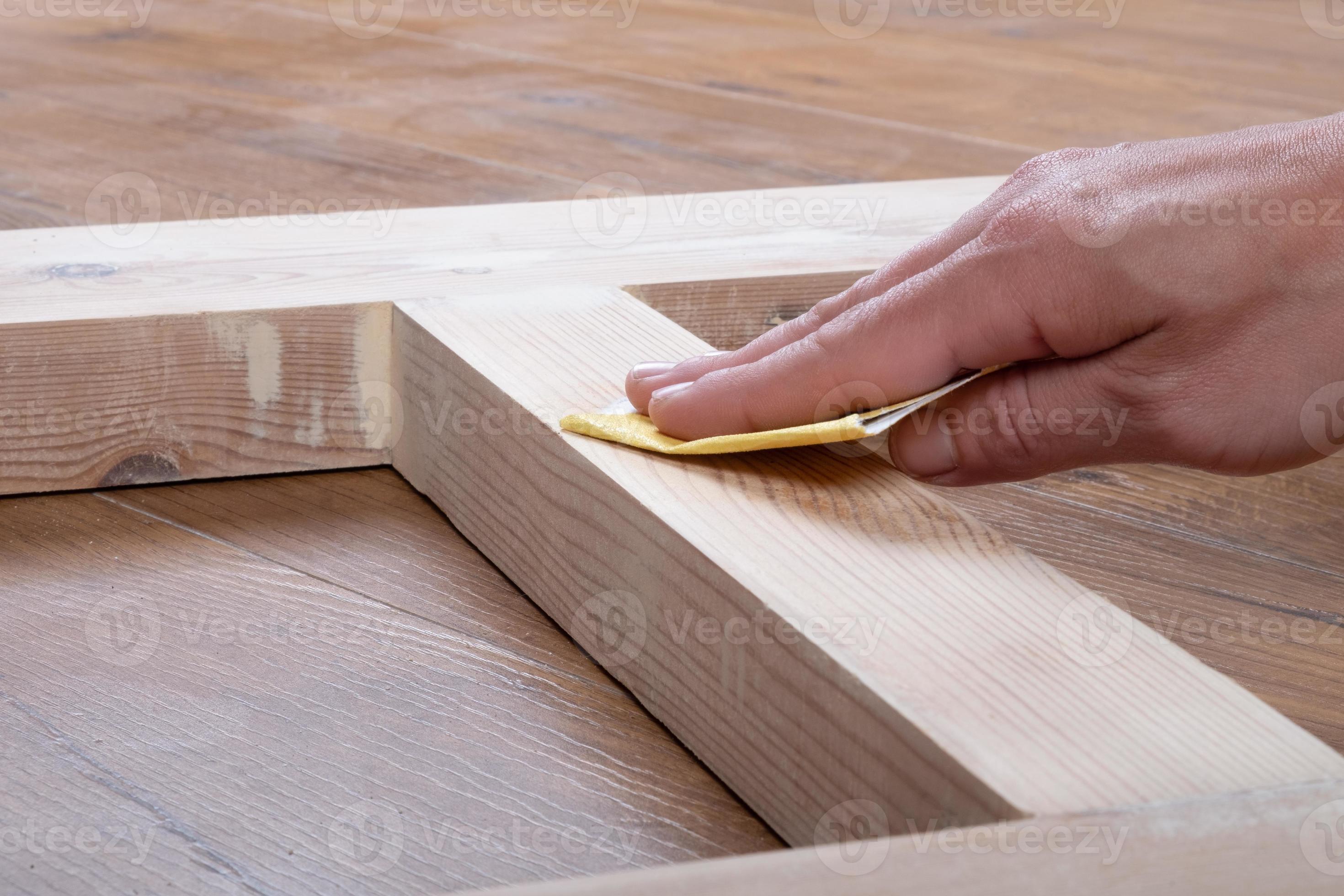 woodworker hand sanding wooden doors for finish paint or stain 10139328