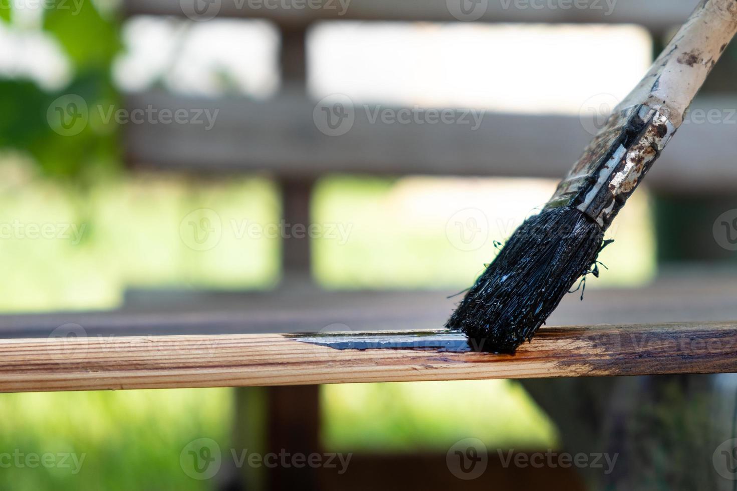 painting brush a wooden surface with a dark varnish photo