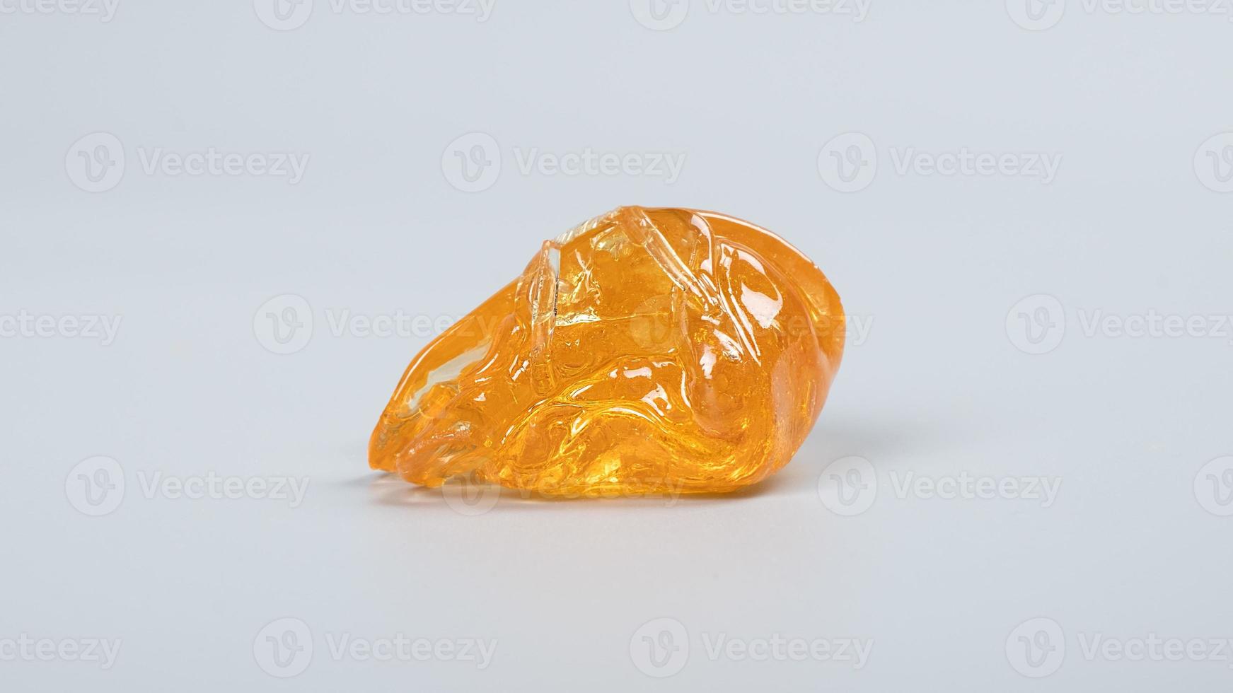 piace golden dab concentrate of cannabis wax close up on gray background, marijuana resin photo