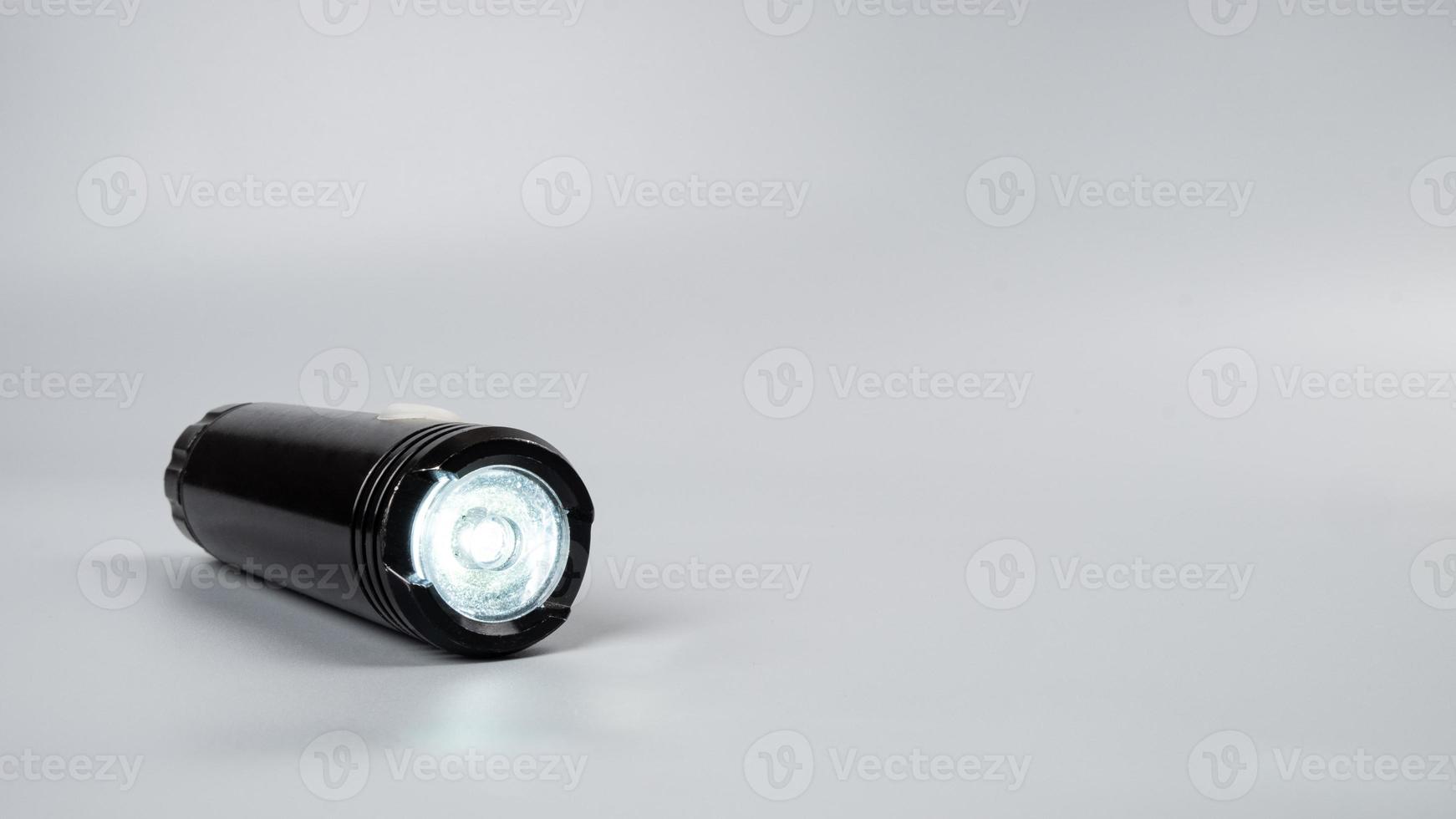 led flashlight on gray background with copy space photo