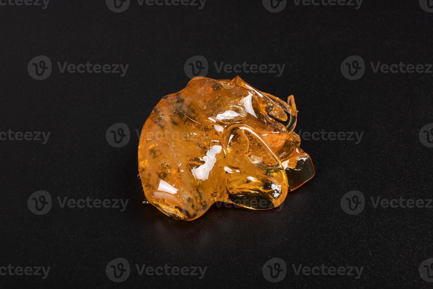 golden dab of cannabis on a dark background, high thc extract photo