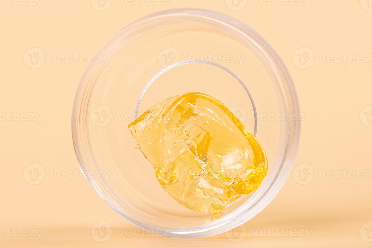 golden cannabis wax in a glass container, high thc dab in glass bottle photo