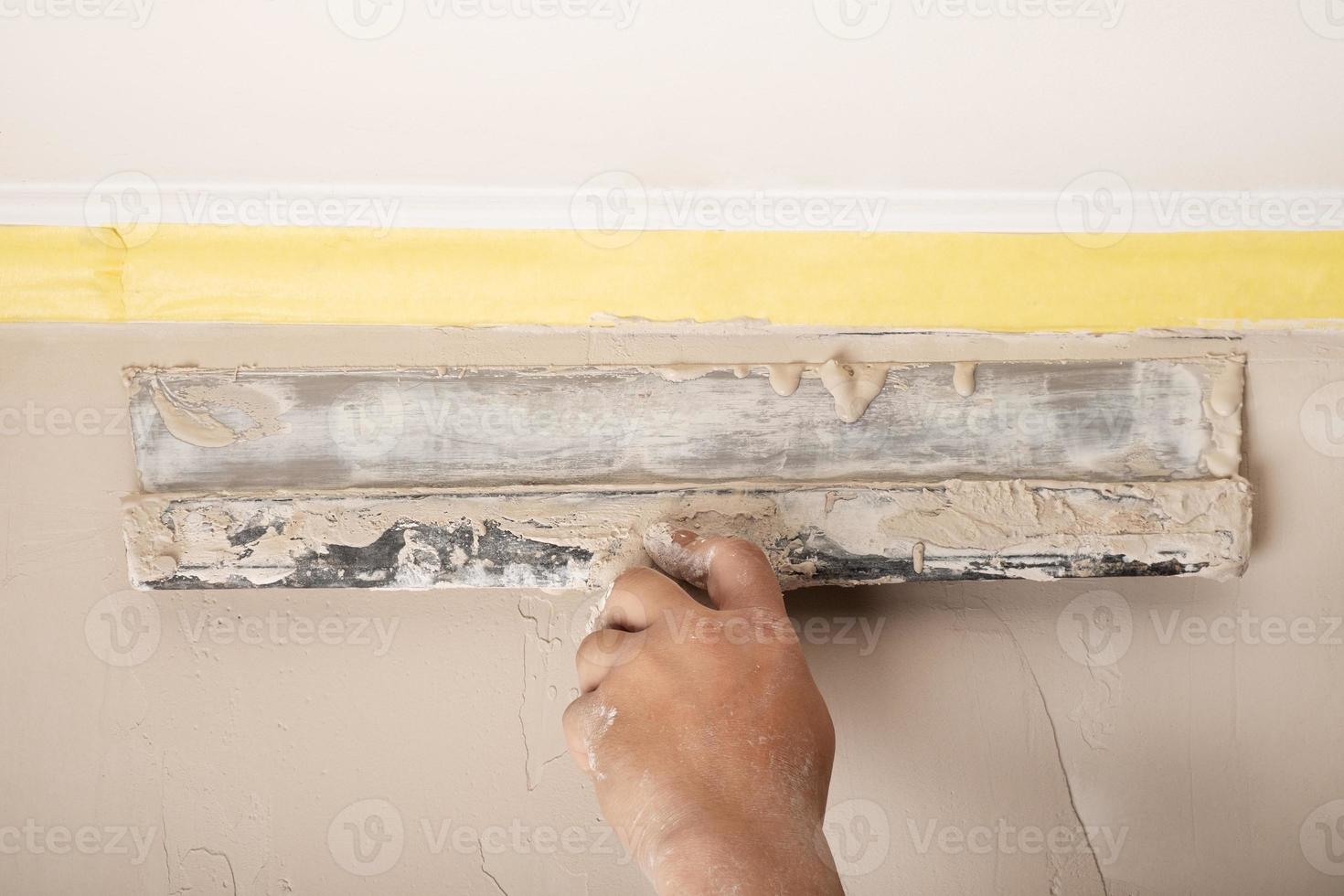 puttying the walls with a spatula, repairing walls removing irregularities photo