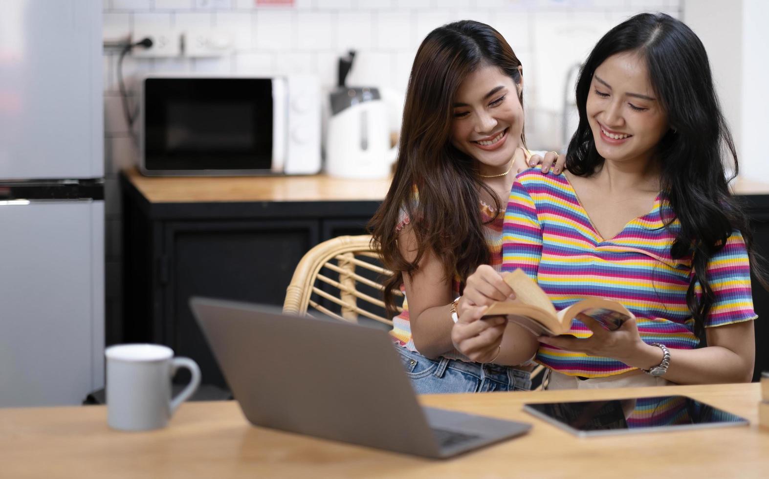 Portrait of young Asian female lovers reading book and spending happy time together, LGBT concept photo