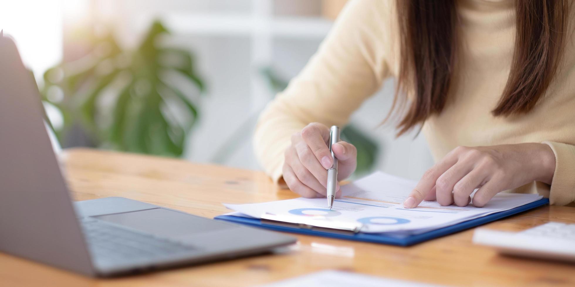 mujer de negocios que calcula los gastos domésticos relacionados con el papeleo financiero en el interior, mujer enfocada que administra los pagos bancarios mensuales que resumen las facturas de servicios públicos y los impuestos en el hogar foto