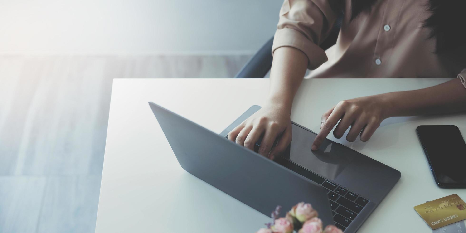 primer plano de manos femeninas usando una computadora portátil en la oficina, manos de mujer escribiendo en el teclado de una computadora portátil en el interior, vista lateral de una mujer de negocios usando una computadora en la oficina foto