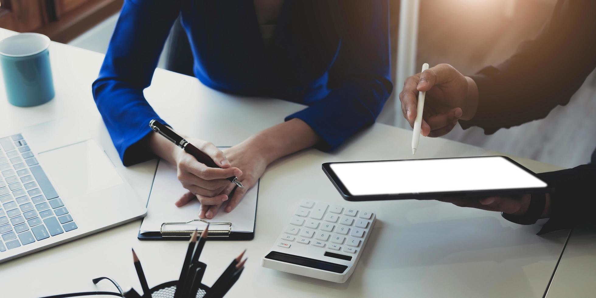 empresario empresario asiático y mujer de negocios discutiendo un nuevo proyecto de negocios en tableta en una reunión moderna en una oficina moderna, concepto casual de negocios asiáticos. foto