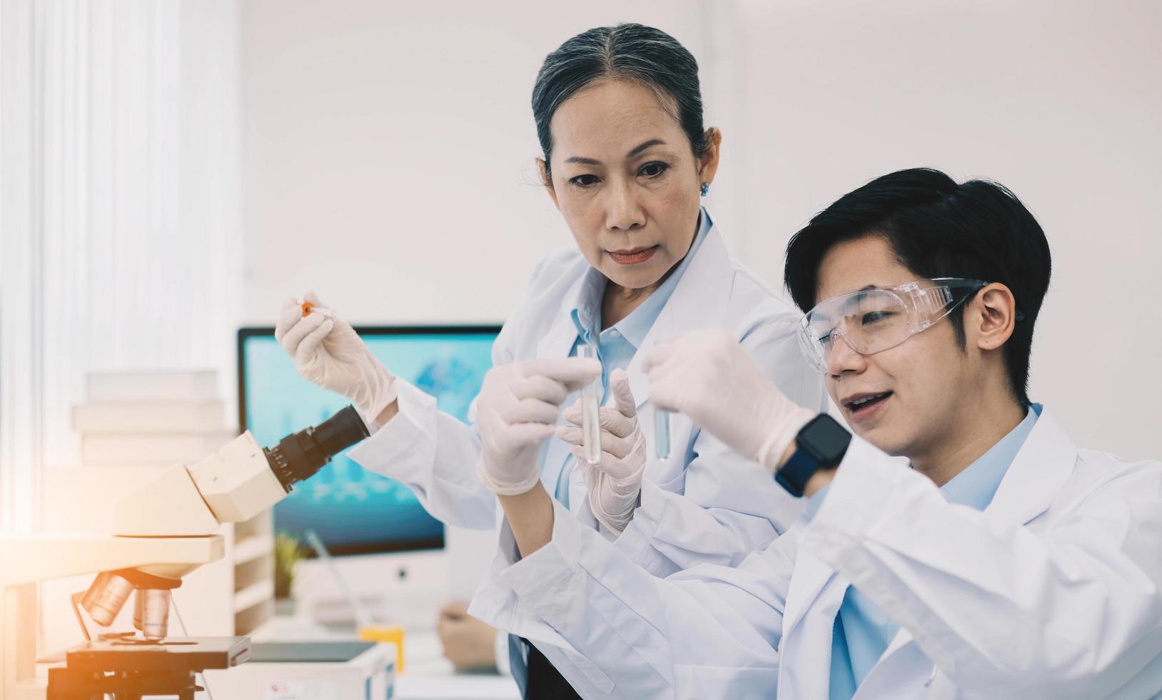 Asian scientists work in hospital pharmacology science research lab. Woman medical scientist and researchers teamwork analyzing innovative virus protective vaccines in health care biology laboratory photo