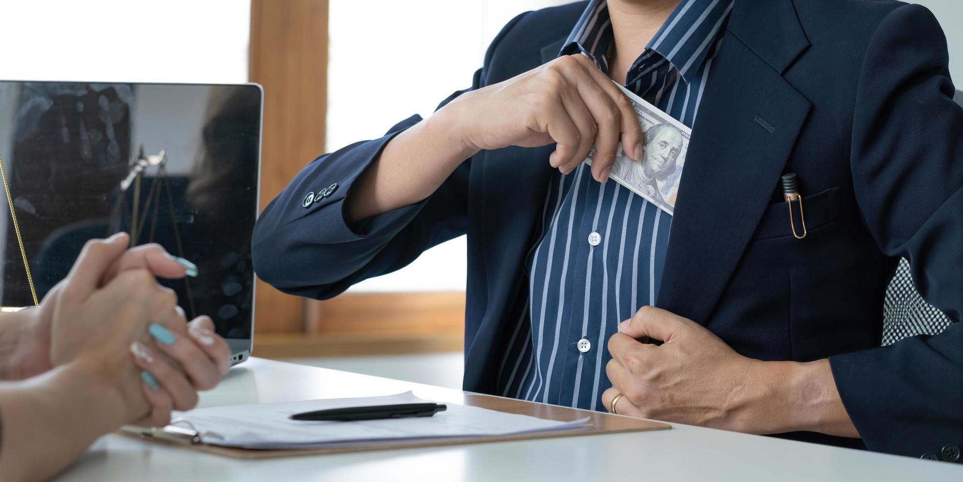 un hombre de negocios toma un billete de dólar en el bolsillo de su traje. concepto de corrupción y soborno. imagen recortada foto