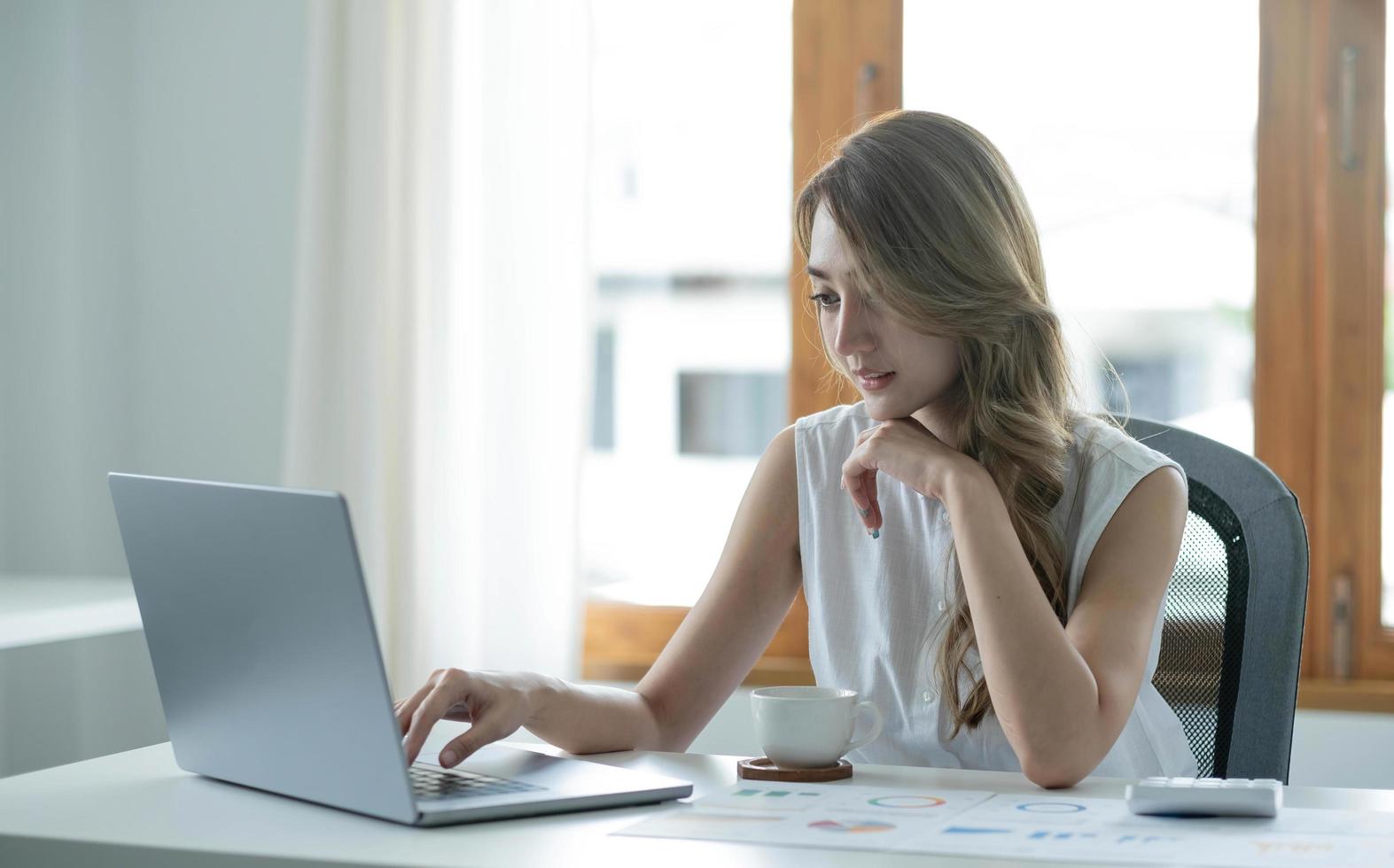 Smiling asian business woman sitting in a modern office. photo