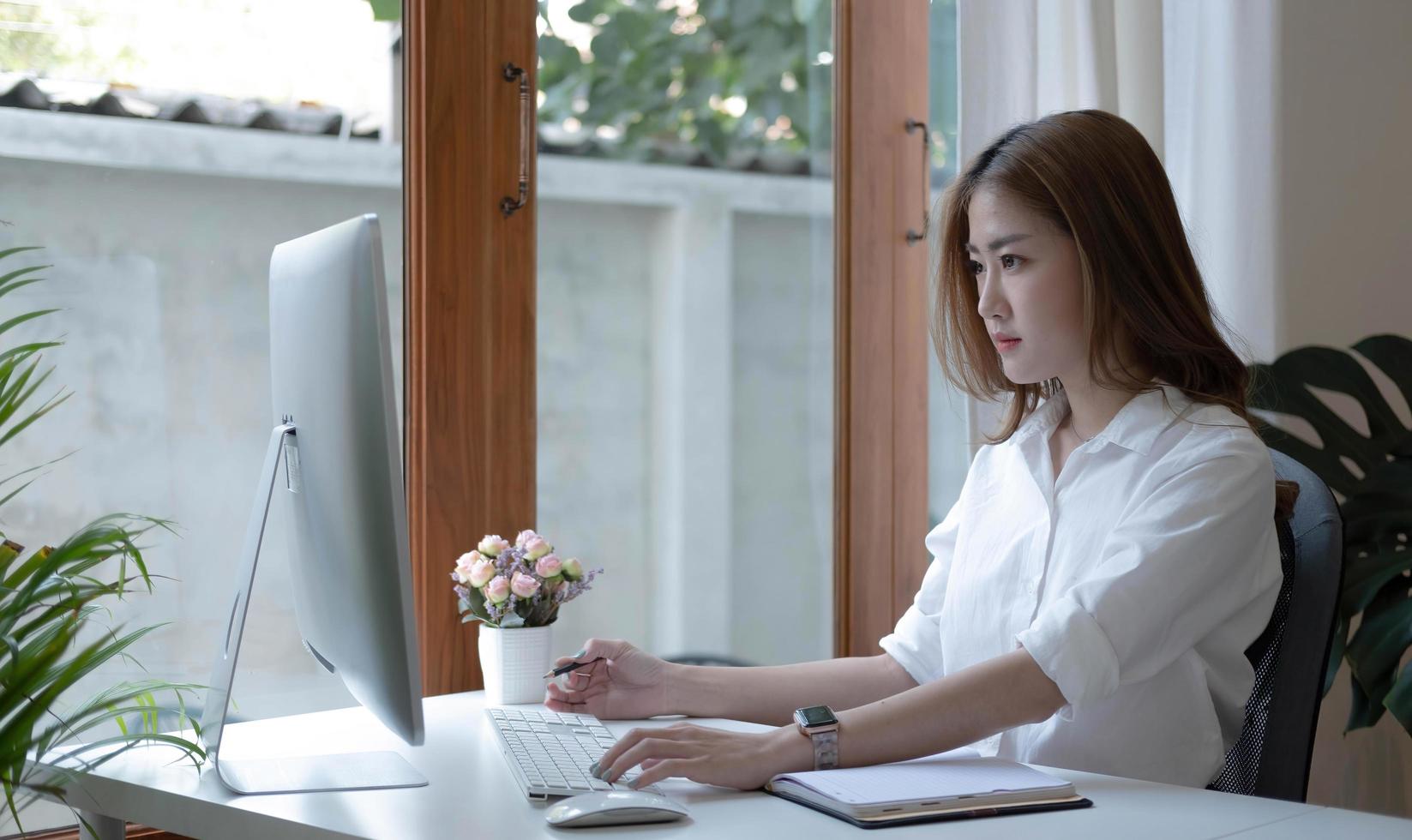 Image of an Asian woman who is tired and overthinking from working with a tablet at the office. photo