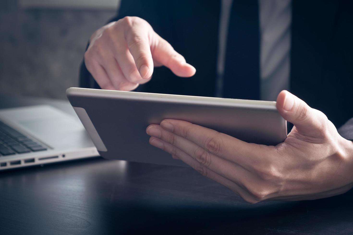 Close up of Businessman using tablet on the office desk. photo