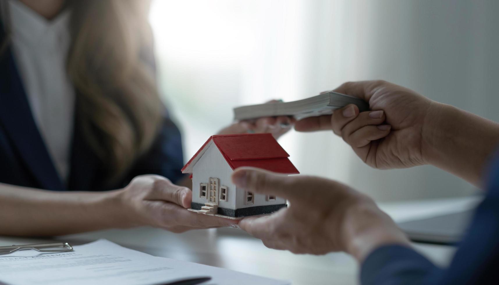 una agente inmobiliaria profesional recibe un pago de préstamo de casa o una tarifa de alquiler de su cliente. concepto de inversión inmobiliaria. imagen recortada foto