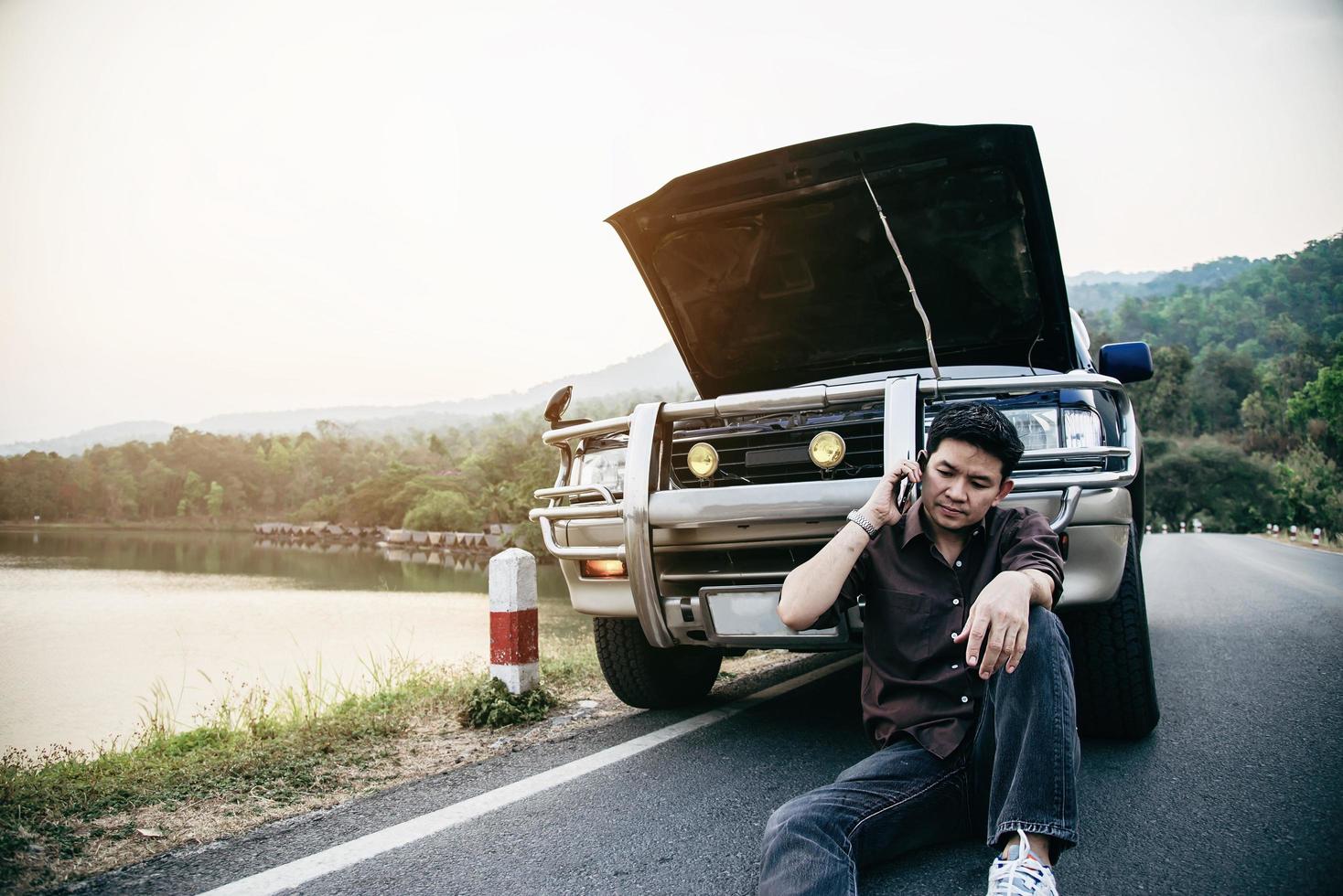 Man try to fix a car engine problem on a local road Chiang mai Thailand - people with car problem transportation concept photo