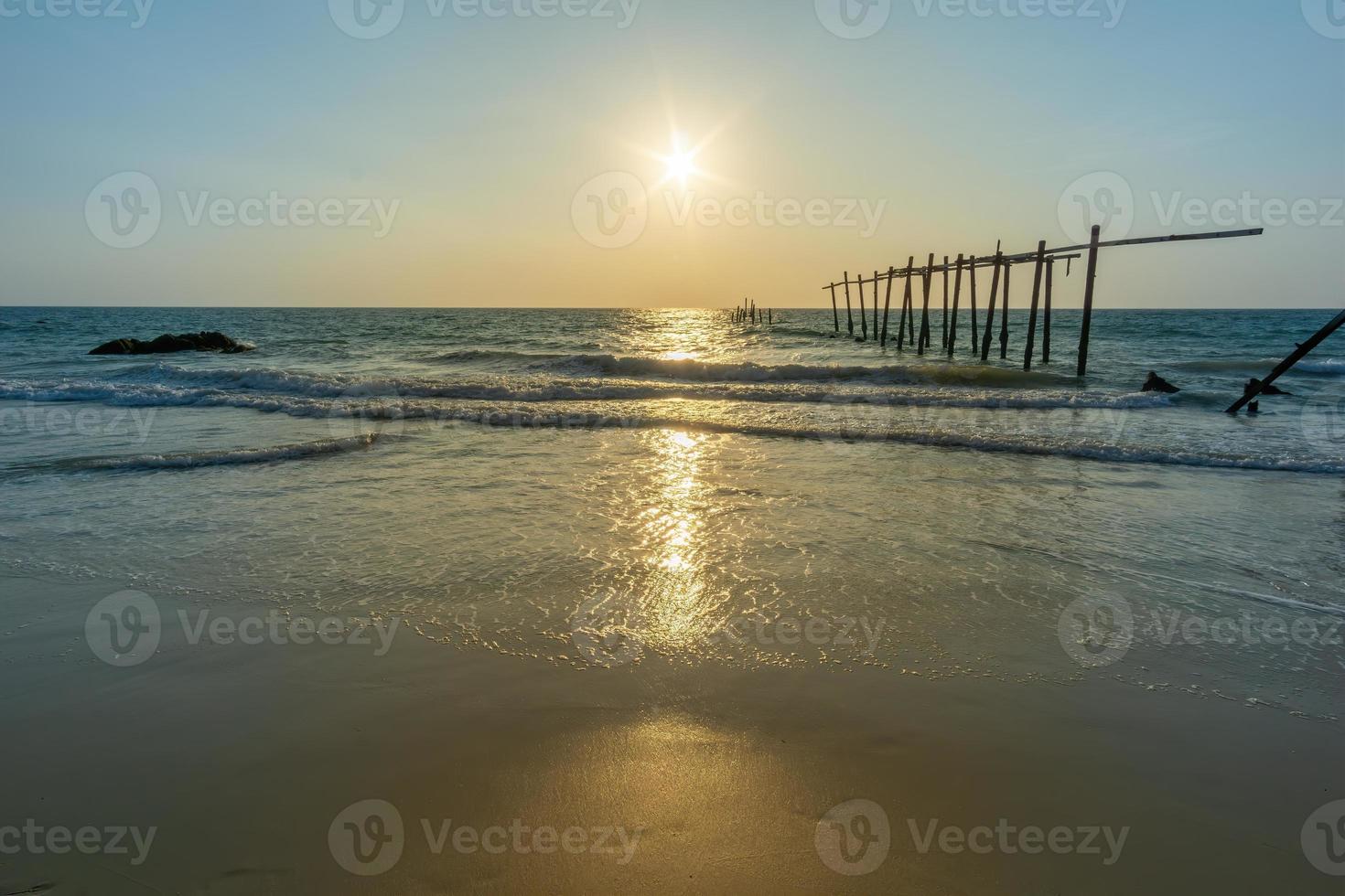 puesta de sol y reflejos del mar, puentes de madera en descomposición, playa de khao pi lai phang nga, tailandia foto