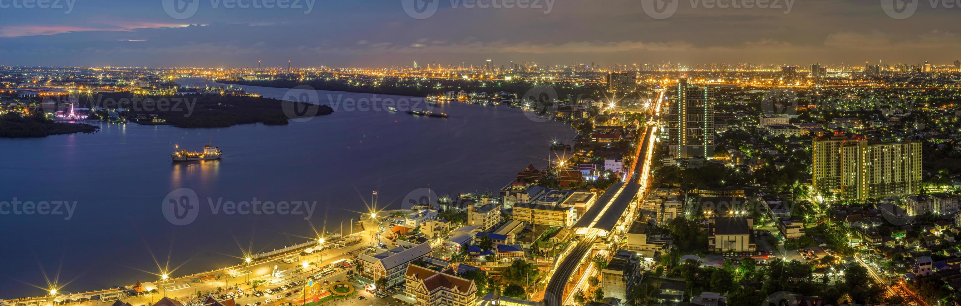 luces panorámicas de las calles y luces de las casas residenciales en los suburbios durante la puesta de sol, tráfico de vehículos de tráfico de barcos en samut prakan, tailandia foto