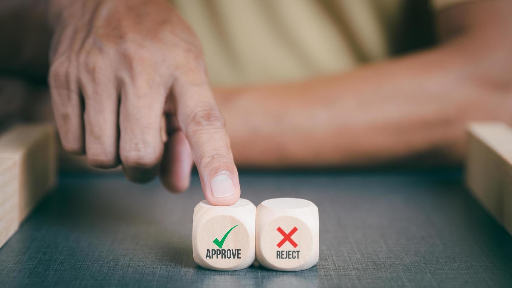 Businessman pointing to a wooden block with a green check mark. Represents approval, concept, agreement, acceptance, satisfaction, assurance, agreed with authority. photo