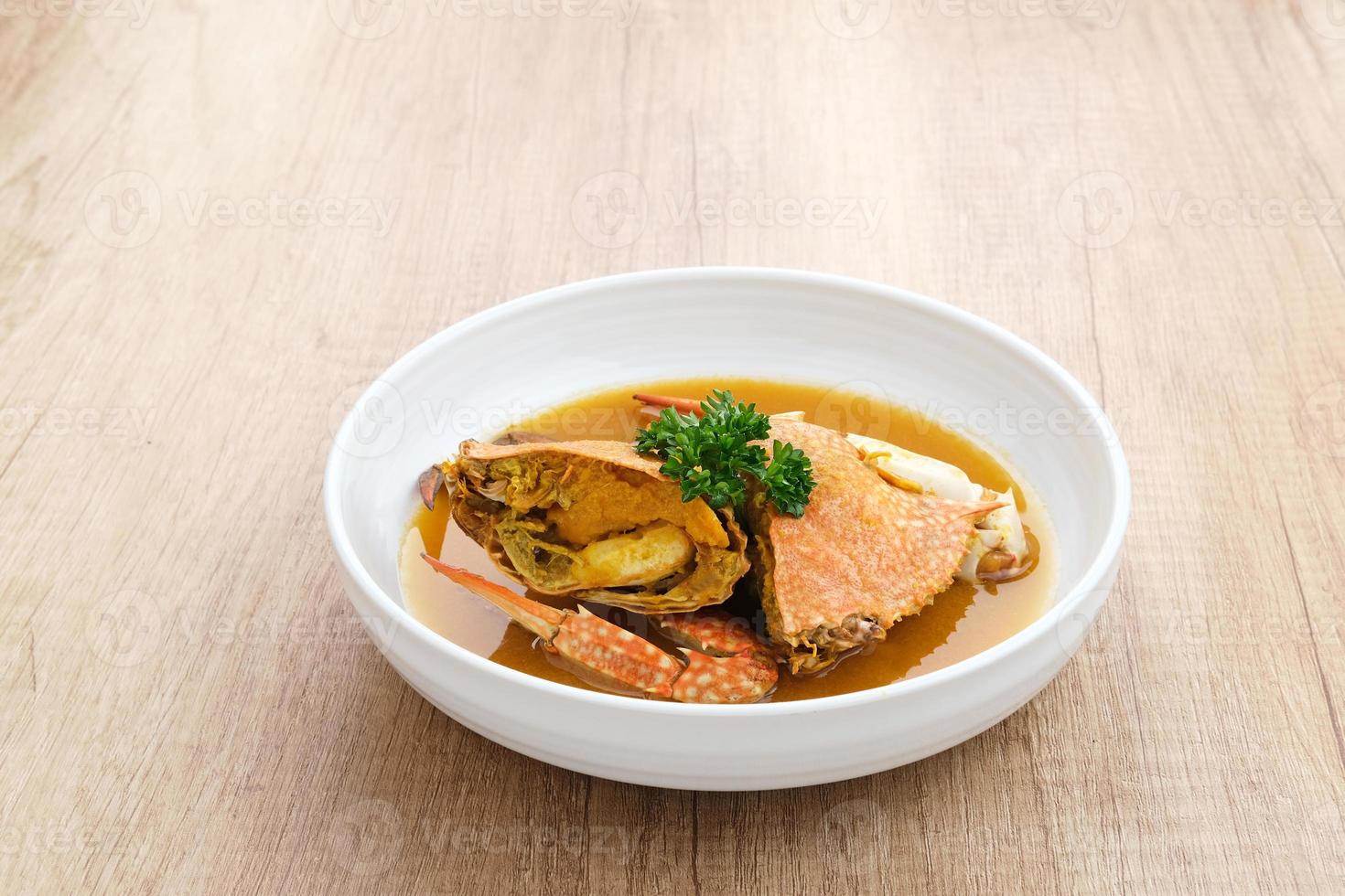 Kepiting Saus Padang, Crab with Padang Sauce, spicy and savory. Served in white bowl. photo