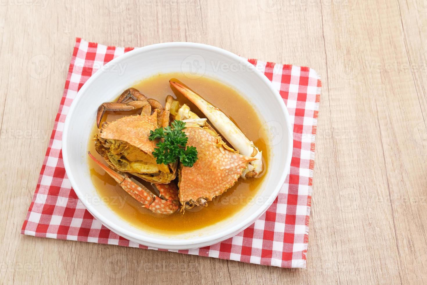 Kepiting Saus Padang, Crab with Padang Sauce, spicy and savory. Served in white bowl. photo