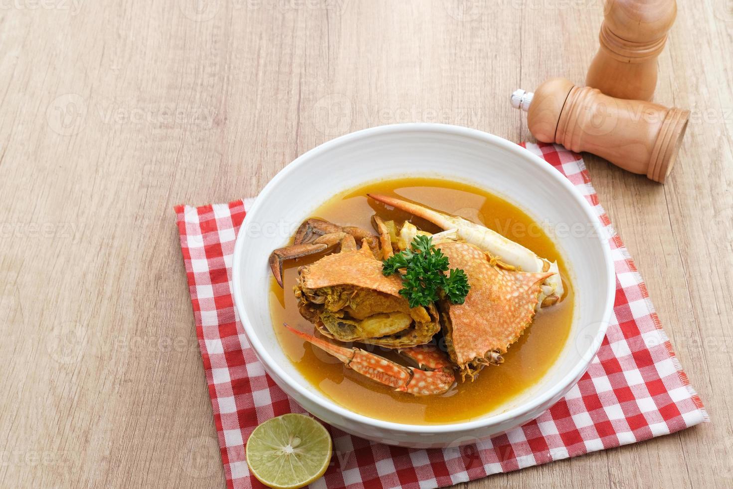 Kepiting Saus Padang, Crab with Padang Sauce, spicy and savory. Served in white bowl. photo