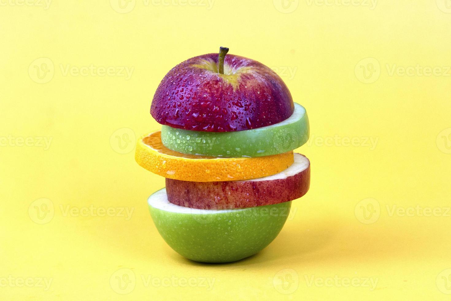 manzana en rodajas con un trozo de limón aislado sobre fondo amarillo. nuevo estilo de aislamiento para el diseño de conceptos de frutas foto