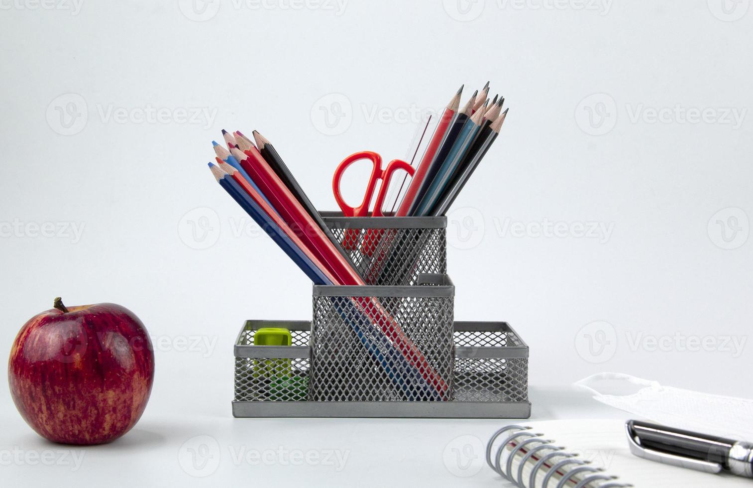 Education elements concepts, color pencils, face mask, paper clips, scissors, ruler, apple isolated on white background. Back to school poster design photo