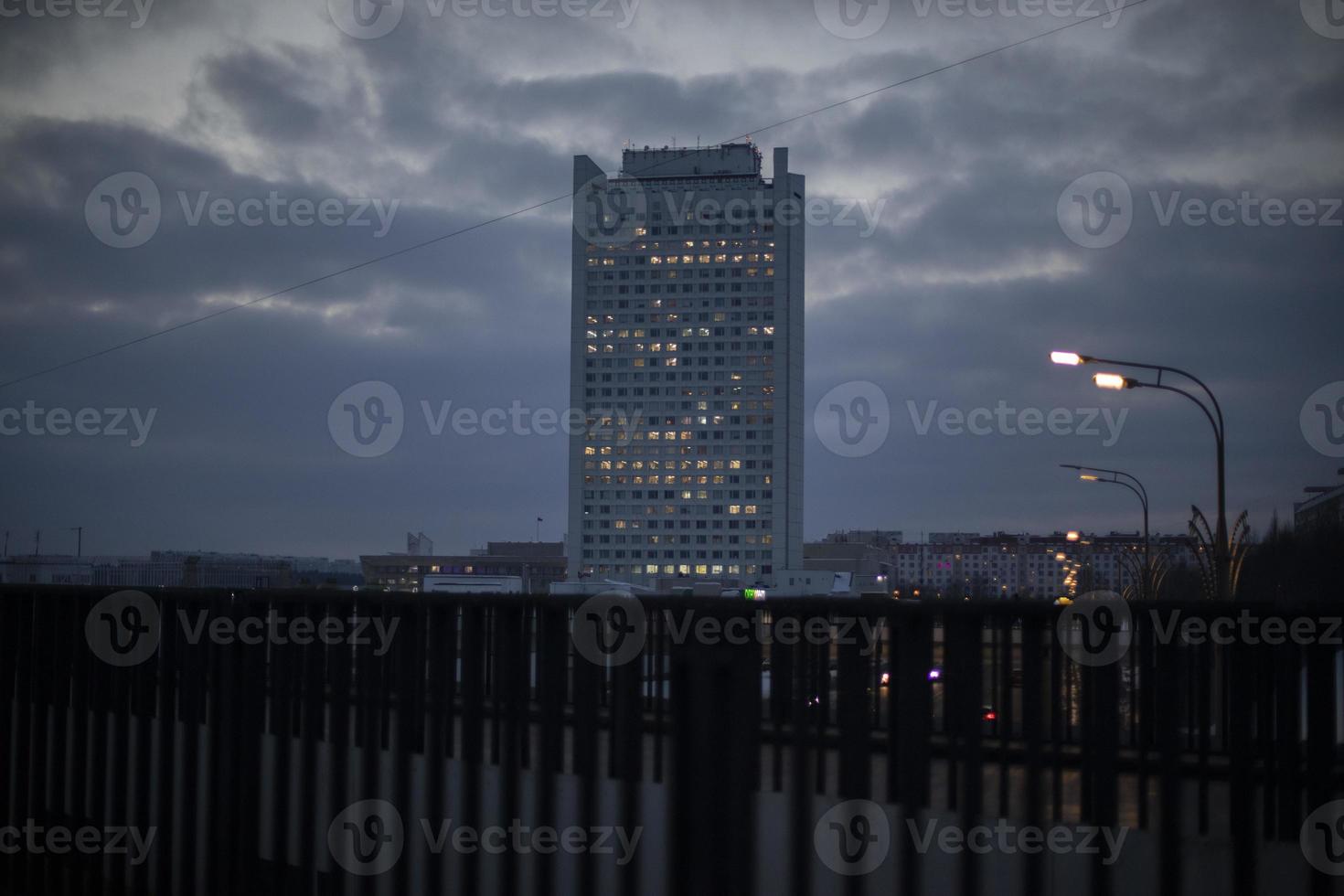 Office building in city in evening. Windows glow in house. photo