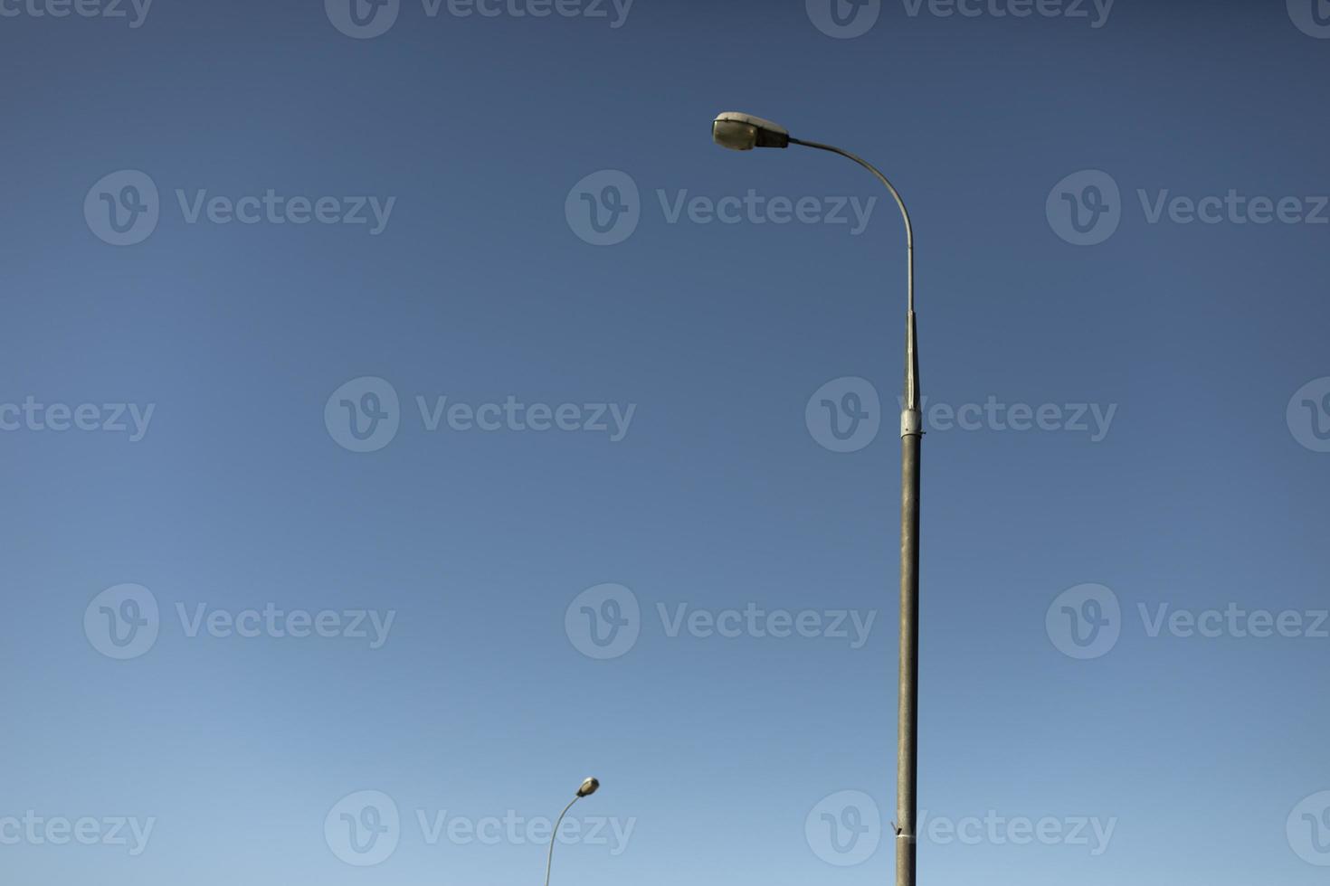 Pillar against sky. Lighting fixture in city. Pole with lamp. photo