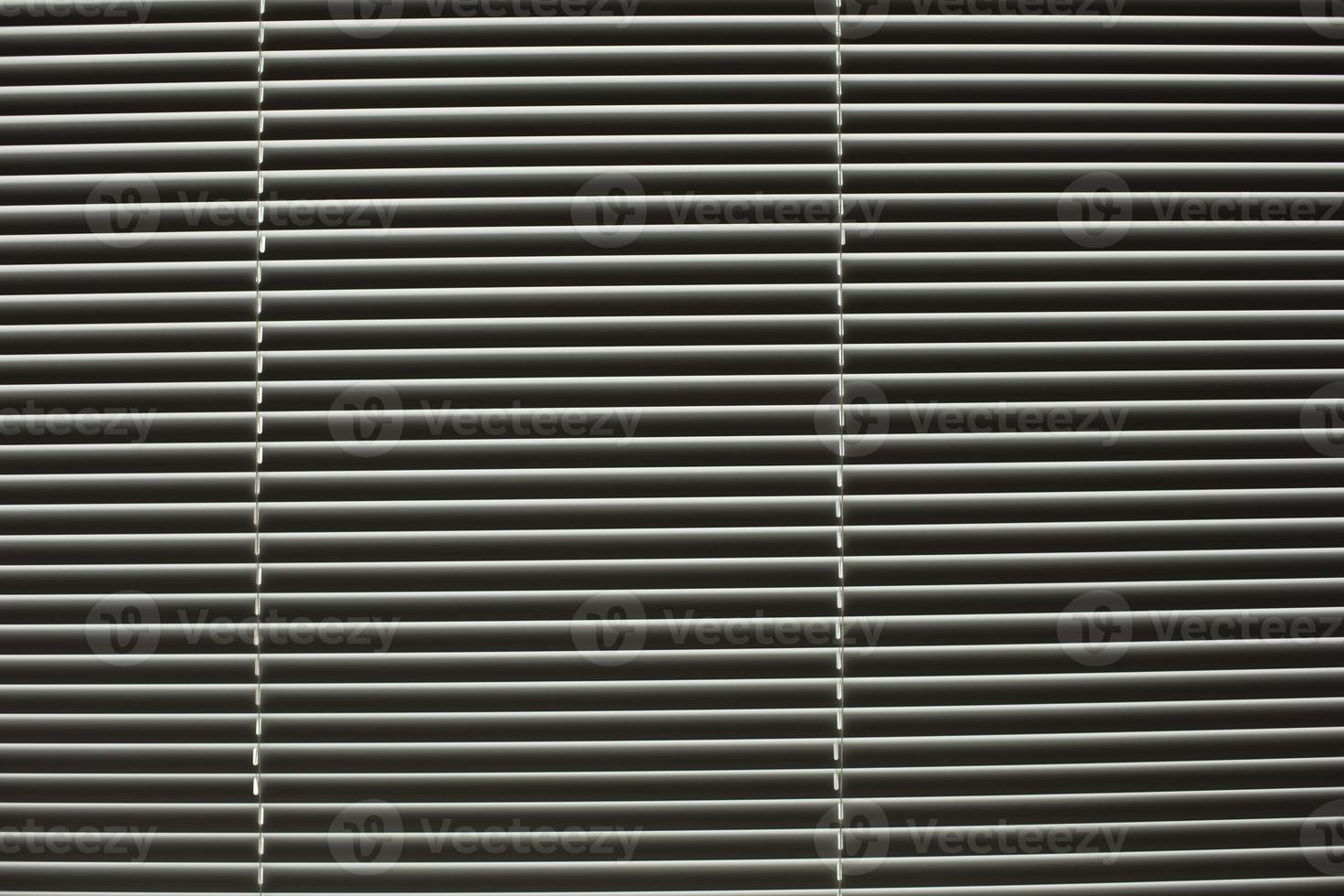 Blinds on window. Daylight through slats of blinds. photo