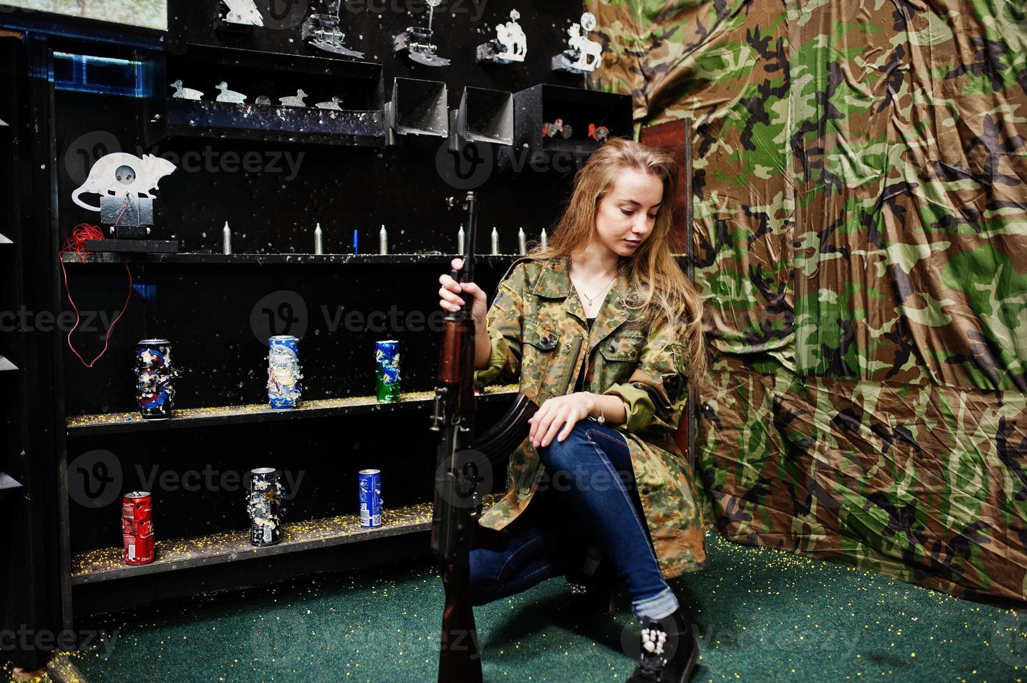 Girl with machine gun at hands on shooting range. photo