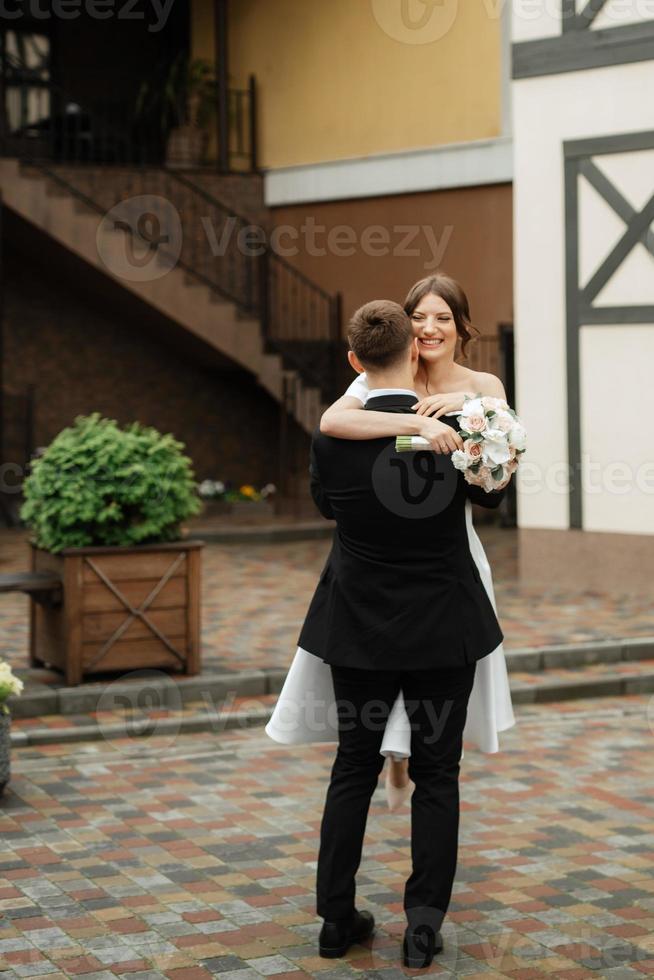 young couple bride and groom in a white short dress photo