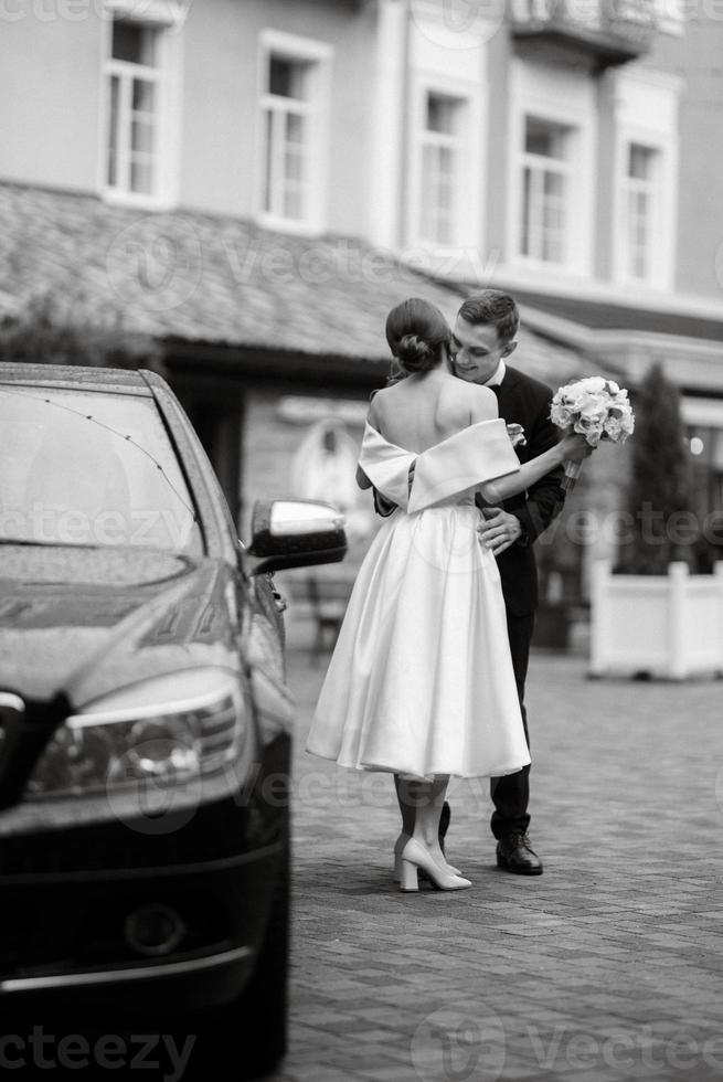 young couple bride and groom in a white short dress photo