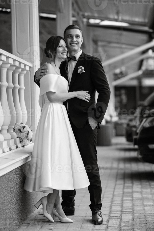 young couple bride and groom in a white short dress photo
