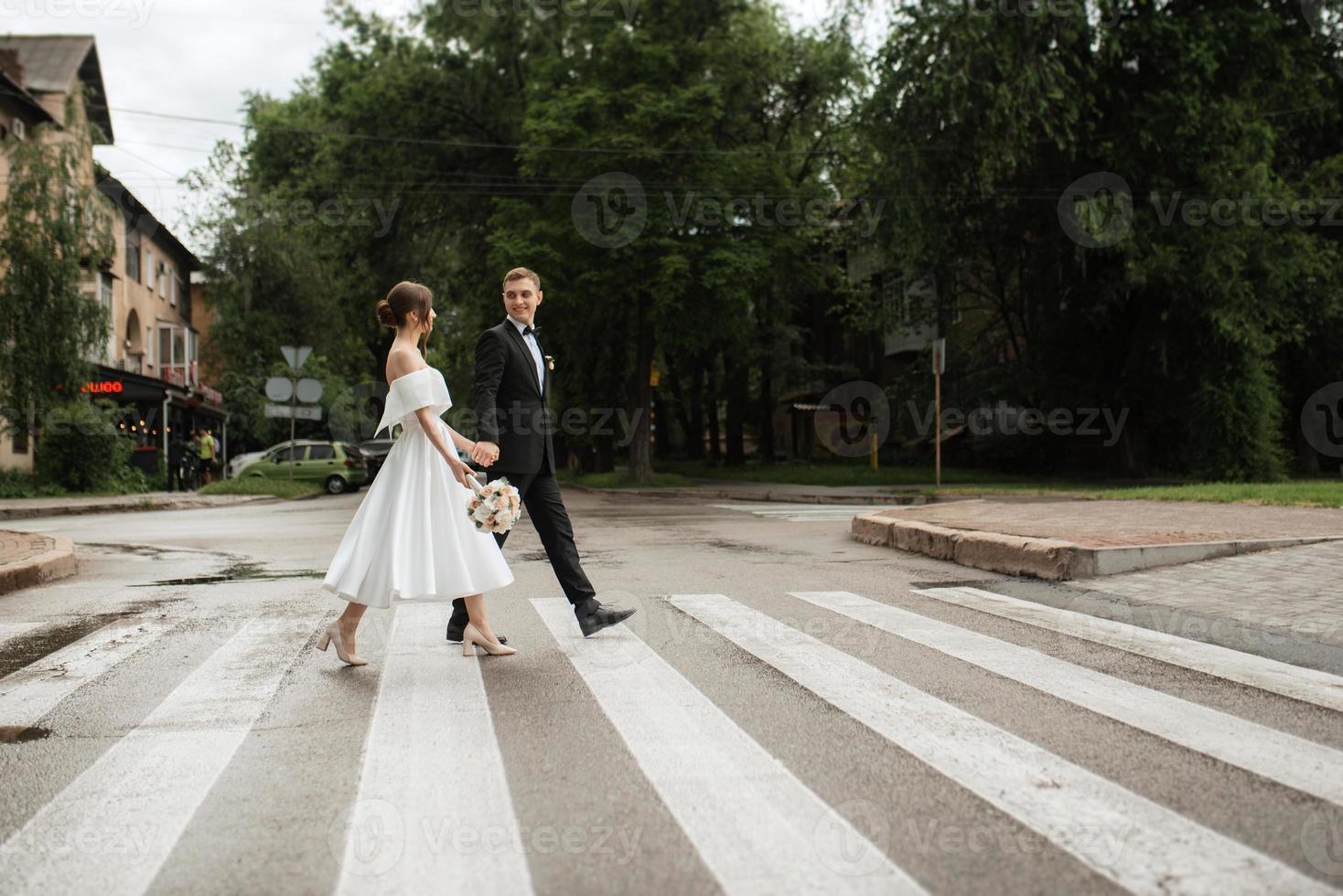 young couple bride and groom in a white short dress photo