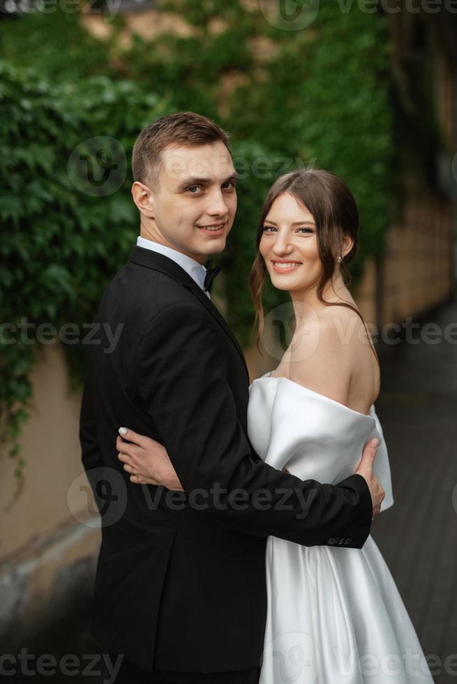 young couple bride and groom in a white short dress photo