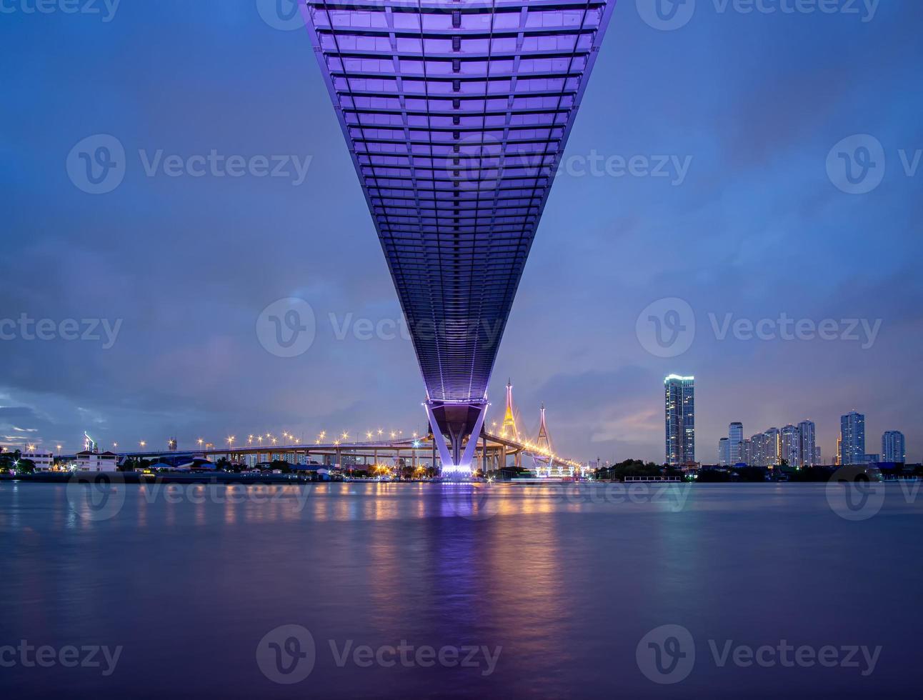 Purple led light under the bridge over the river On a cloudy day in the sky. Bhumibol Bridge, Samut Prakan, Thailand photo