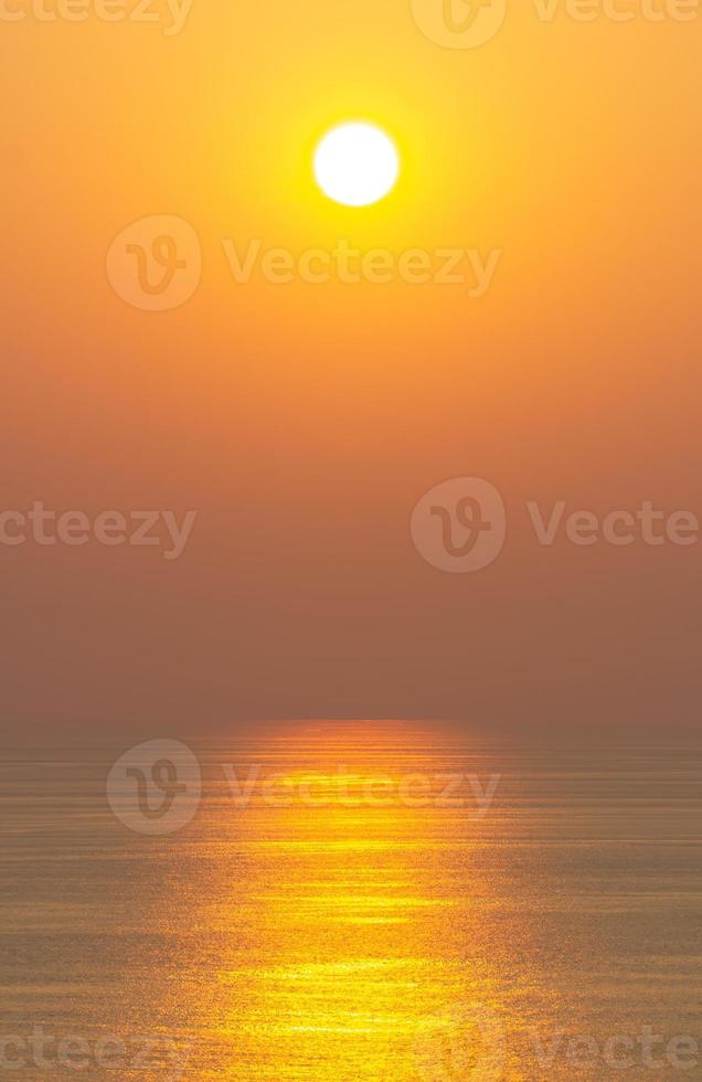 The sunset, the sea surface reflects the sunlight in gold. Clear sky, orange without clouds photo