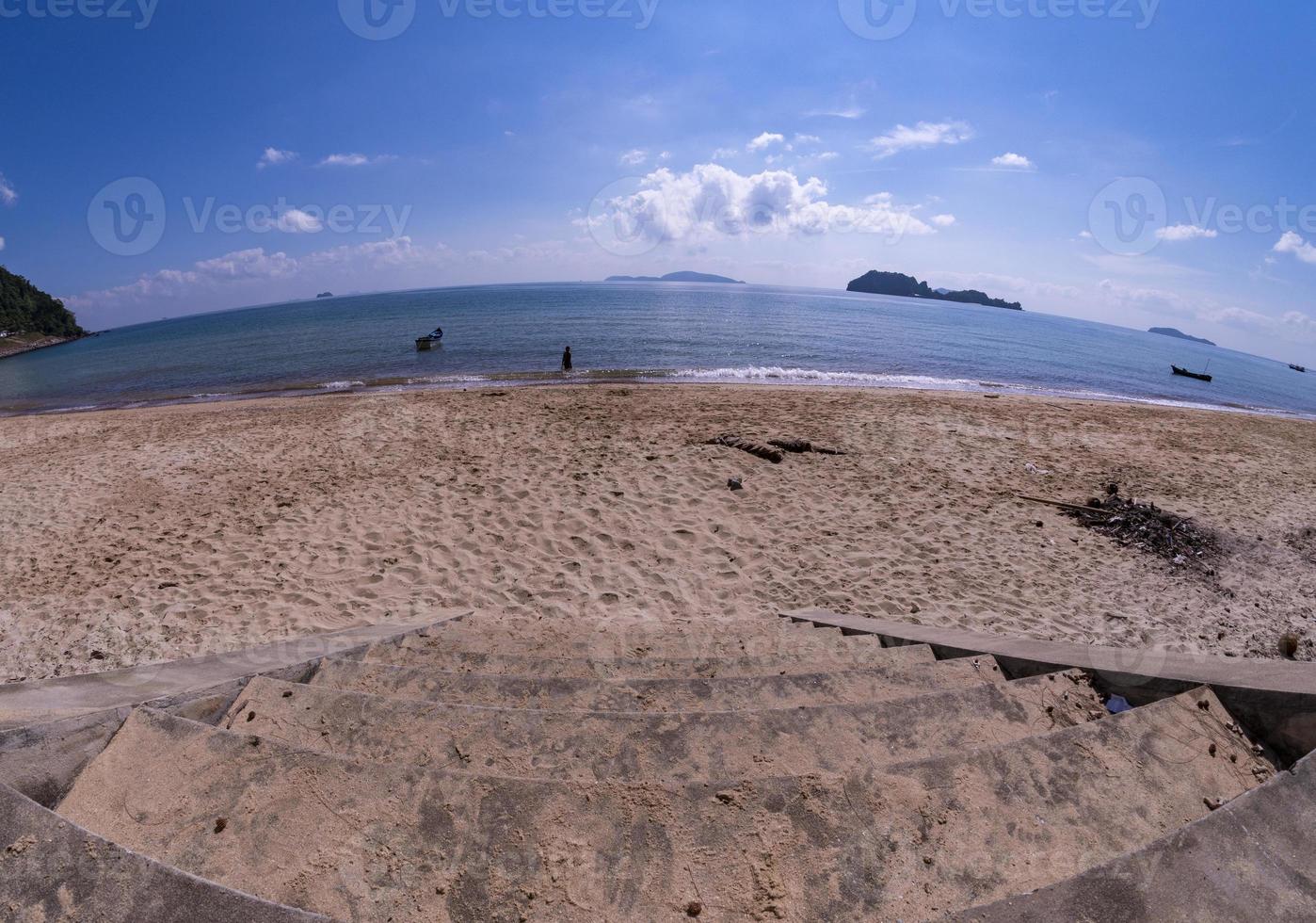 The stairs down to the beach. The beach with the sky and the blue sea. photo