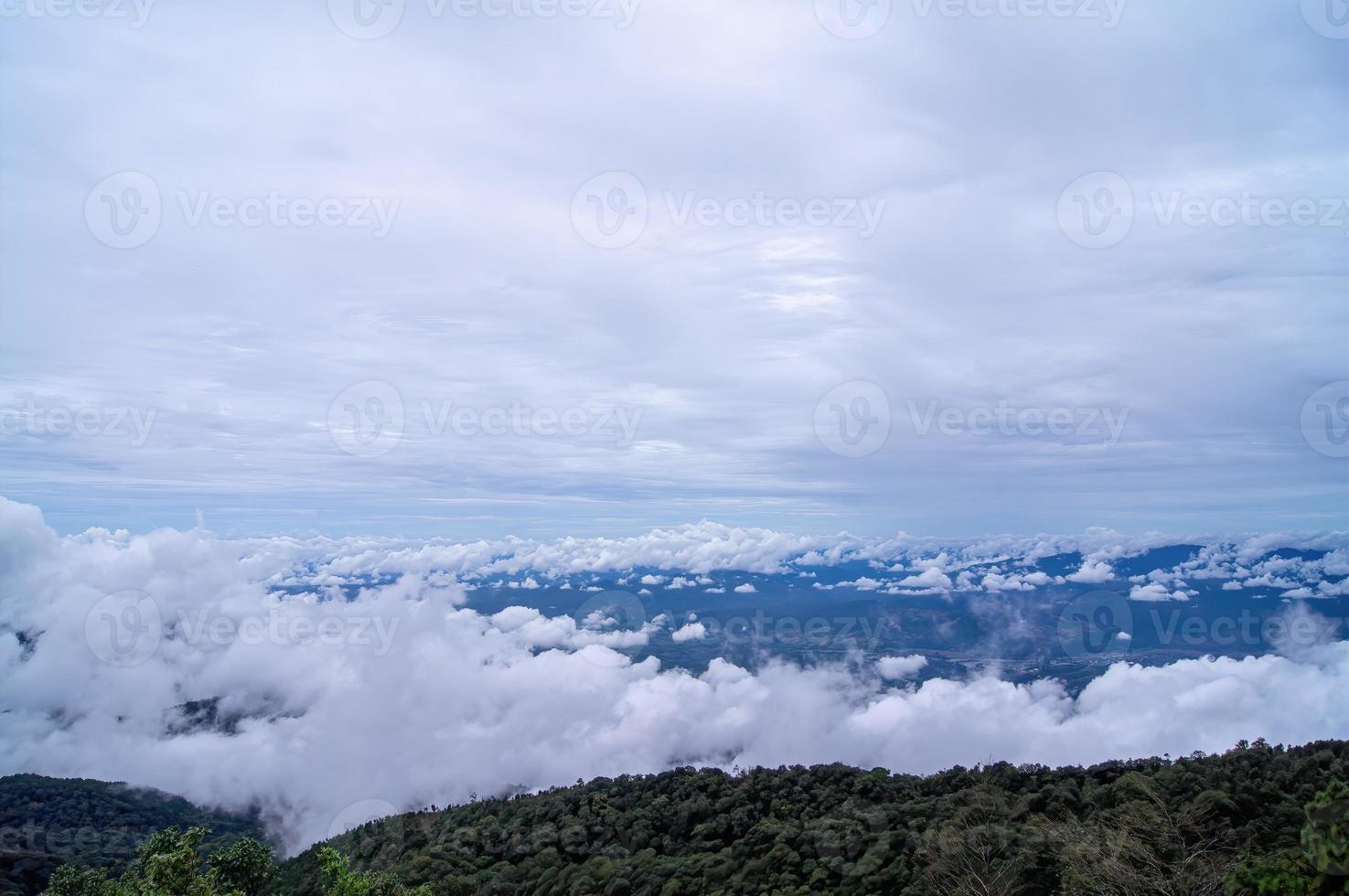 Green mountain scenery fog in the mountains a. The sky is covered with white clouds. photo