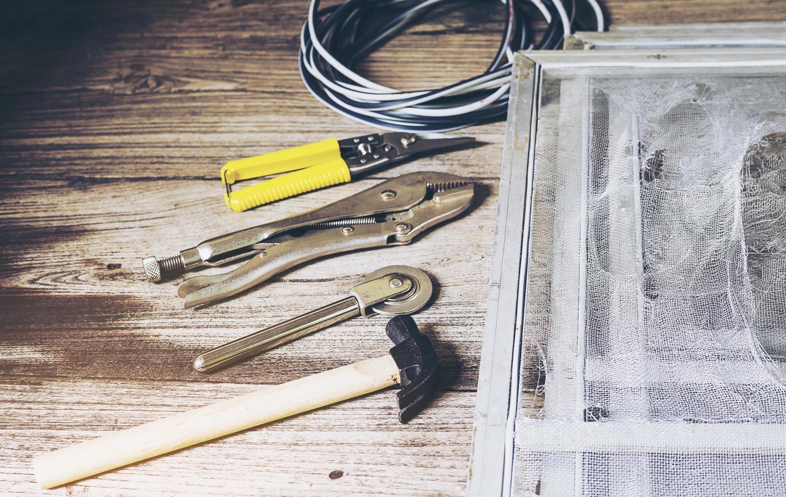 Hand tools set and damaged mosquito wire screen which need to be fixed photo